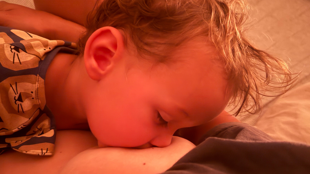 Mother breastfeeding newborn while learning breastfeeding positioning and attachment