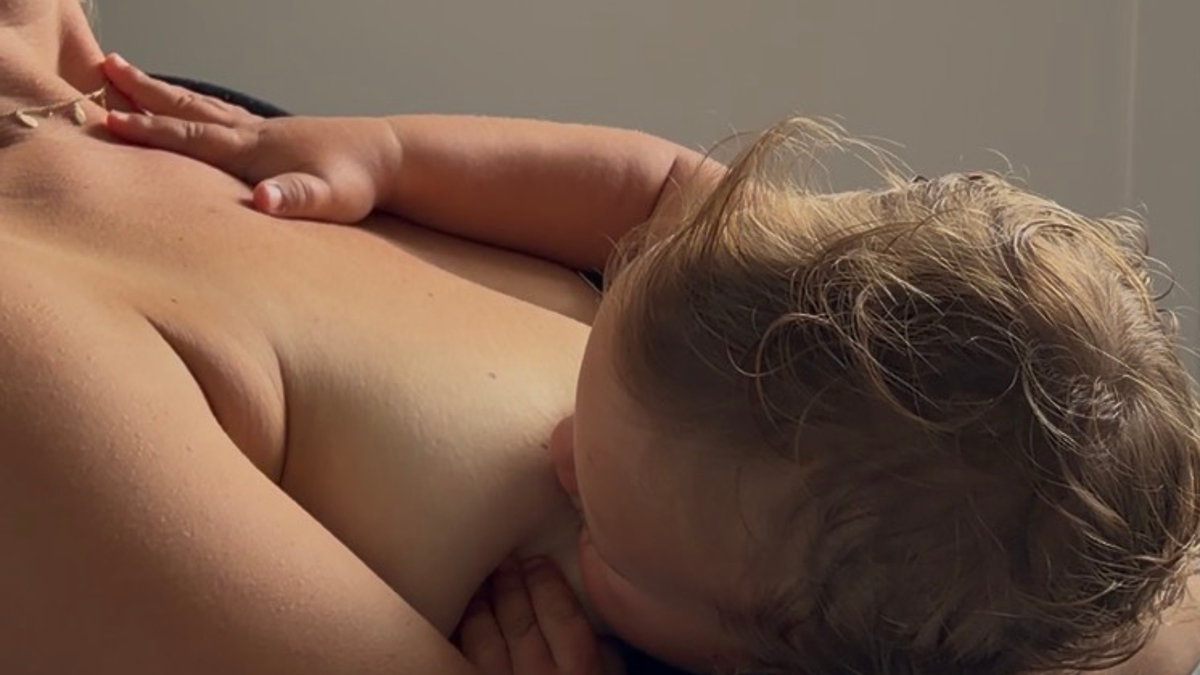 Mother breastfeeding baby with suspected tongue tie
